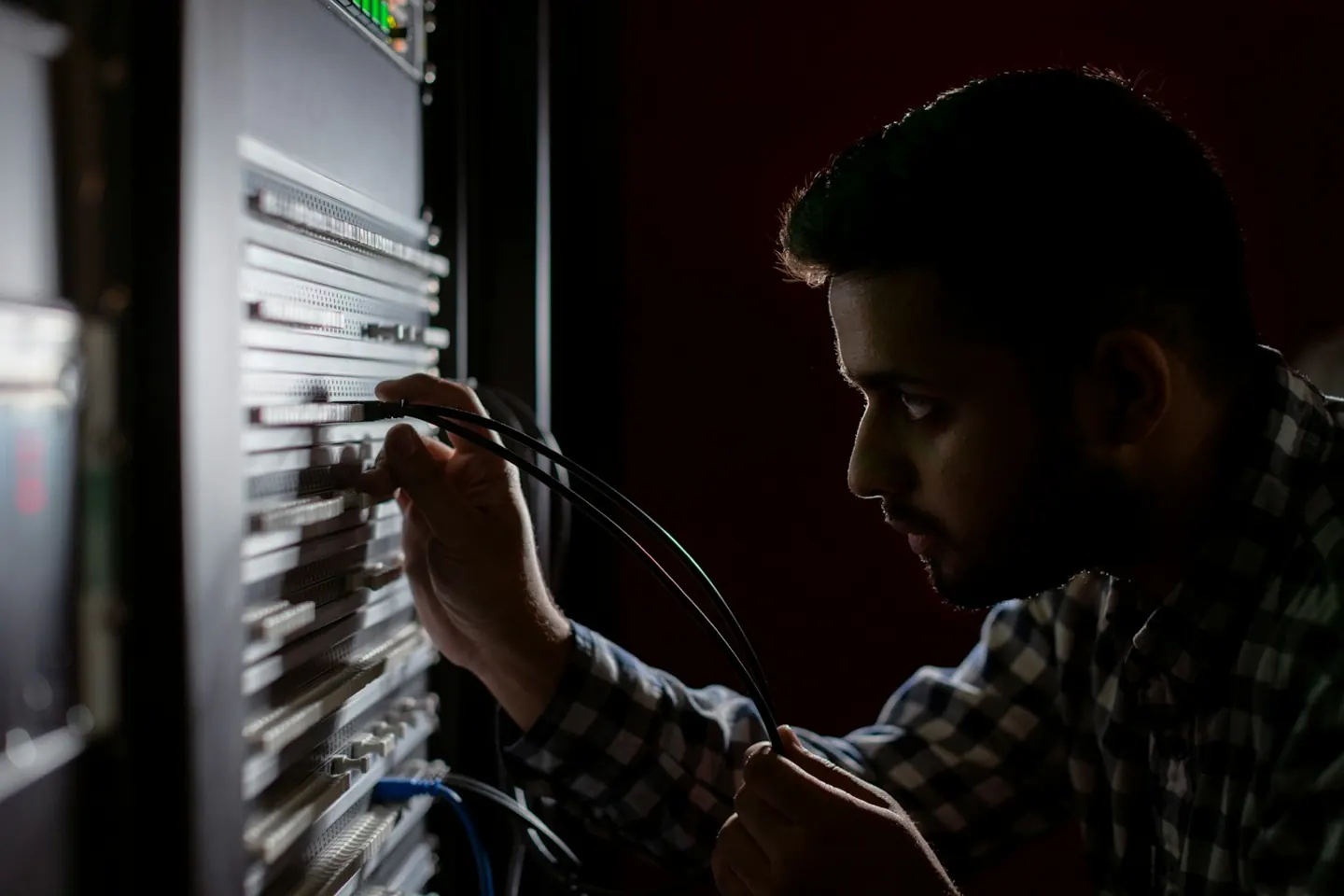A technician connecting cables in a network rack